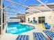 Beautiful in-ground pool is surrounded by a screened enclosure, furniture, and an outdoor dining area at 824 Bloomingdale Dr, Davenport, FL 33897