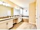 Bright bathroom with double vanity sinks, a soaking tub, and elegant tile flooring at 8974 Cabot Cliffs Dr, Davenport, FL 33896