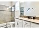 Modern bathroom with a glass enclosed shower, granite countertop and white cabinets at 8974 Cabot Cliffs Dr, Davenport, FL 33896