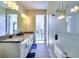 Bright bathroom with double sinks, tile floor, shower, and outdoor access to the pool at 8974 Cabot Cliffs Dr, Davenport, FL 33896