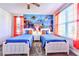 A fun bedroom with two twin beds, an ocean themed mural and red curtains at 8974 Cabot Cliffs Dr, Davenport, FL 33896