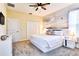 Bright bedroom featuring a queen sized bed with white bedding, an ocean mural and a ceiling fan at 8974 Cabot Cliffs Dr, Davenport, FL 33896
