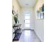 Inviting entryway featuring tiled floors, modern console table, decorative wall art and a door with frosted glass panels at 8974 Cabot Cliffs Dr, Davenport, FL 33896