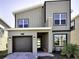 Contemporary two-story home with a modern design, featuring a gray exterior, clean lines, and a single-car garage at 8974 Cabot Cliffs Dr, Davenport, FL 33896
