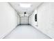 Clean, well-lit empty garage with white walls and a sealed concrete floor at 8974 Cabot Cliffs Dr, Davenport, FL 33896