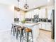 Modern kitchen features white cabinetry, stainless steel appliances, a stylish backsplash, and an island with seating at 8974 Cabot Cliffs Dr, Davenport, FL 33896