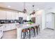 Bright kitchen with white cabinets, stainless steel appliances, gray backsplash and a central island with bar stools at 8974 Cabot Cliffs Dr, Davenport, FL 33896