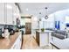 Bright, modern kitchen featuring white cabinets, stainless steel appliances, island with seating, open to the living area at 8974 Cabot Cliffs Dr, Davenport, FL 33896