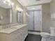 Bathroom featuring a double marble vanity, and a frameless glass shower with decorative tile and upscale fixtures at 920 Spring Park St # 301, Celebration, FL 34747