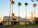 Charming clubhouse exterior with classic car, flagpole, and windmill water tower surrounded by beautiful palm trees at 920 Spring Park St # 301, Celebration, FL 34747