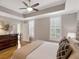 Bright main bedroom with hardwood floors, tray ceiling, ceiling fan and abundant light from two windows at 920 Spring Park St # 301, Celebration, FL 34747