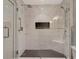 Upscale marble tiled frameless glass shower with two shower heads, corner seat and recessed storage shelf at 920 Spring Park St # 301, Celebration, FL 34747