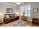 Sitting room with large bright window, leather sofa, ceiling fan, and decorative rug on hardwood floor at 920 Spring Park St # 301, Celebration, FL 34747