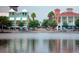 Picturesque waterfront view of colorful buildings along the water, complete with outdoor dining areas and palm trees at 920 Spring Park St # 301, Celebration, FL 34747
