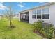 Well maintained backyard featuring green grass and the rear of the home with a screened patio at 1895 Spring Shower Cir, Kissimmee, FL 34744
