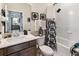 Well-lit bathroom featuring a shower-tub combo, decorative accents, and dark wood cabinets at 1895 Spring Shower Cir, Kissimmee, FL 34744