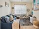 Bright bedroom furnished with a comfortable blue sofa, desk, and stylish décor illuminated by natural light at 1895 Spring Shower Cir, Kissimmee, FL 34744