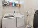 Well-lit laundry room features a washer, dryer, shelving, and space-saving ironing board at 1895 Spring Shower Cir, Kissimmee, FL 34744