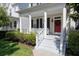 Inviting front porch featuring classic columns, white railings, and a cheerful red front door at 1236 Aquila Loop, Celebration, FL 34747