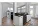 Open-concept kitchen with granite countertops, white cabinetry, and stainless steel appliances overlooks the adjacent living space at 1236 Aquila Loop, Celebration, FL 34747