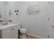 Bright powder room featuring a white vanity, decorative mirror and wall art, and tile flooring at 1236 Aquila Loop, Celebration, FL 34747