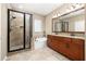 Elegant bathroom features a glass-enclosed shower, a soaking tub, and double vanity with granite countertops at 1592 Castile St, Celebration, FL 34747