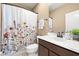 Functional bathroom featuring a vanity with fresh flowers and a shower/tub with a decorative floral curtain at 1592 Castile St, Celebration, FL 34747