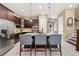 Modern kitchen with dark cabinets, stainless steel appliances, and a granite island with bar seating at 1592 Castile St, Celebration, FL 34747