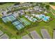 Expansive aerial view of the community center showcasing pools, tennis courts, bocce ball, parking, and green space at 1598 Whitewood Ct, Kissimmee, FL 34747