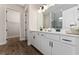 Bright bathroom with white cabinetry, stone countertops, dual sinks, and luxurious marble tiled shower at 1598 Whitewood Ct, Kissimmee, FL 34747