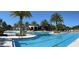Stunning view of community pool and clubhouse surrounded by lush palm trees under a clear blue sky at 1598 Whitewood Ct, Kissimmee, FL 34747