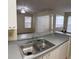 Open kitchen with gray countertops, sink, and a view to the living room at 1608 Columbia Arms Cir # 126, Kissimmee, FL 34741