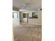 Carpeted living room with a view of a kitchen and laundry closet at 1608 Columbia Arms Cir # 126, Kissimmee, FL 34741