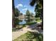 Scenic view of a pond reflecting nearby buildings, surrounded by lush greenery and walking paths at 1608 Columbia Arms Cir # 126, Kissimmee, FL 34741