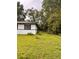 View of a lush green backyard with mature trees and a white house at 1615 Ne 9Th St, Ocala, FL 34470