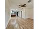 Spacious living room with new wood flooring, ceiling fan, and a view into the modern kitchen at 1615 Ne 9Th St, Ocala, FL 34470