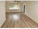 Bright living room with a large window, wood-look flooring, and neutral paint at 1615 Ne 9Th St, Ocala, FL 34470