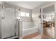 Bright bathroom featuring a shower with glass door, soaker tub, and natural light at 1704 Pine Ridge Dr, Davenport, FL 33896