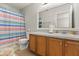 Bathroom featuring a vanity with wooden cabinets and a striped shower curtain at 1704 Pine Ridge Dr, Davenport, FL 33896