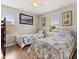 Cozy bedroom with two twin beds, each adorned with floral bedding, complemented by art and natural light at 1704 Pine Ridge Dr, Davenport, FL 33896