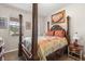 Bedroom with a four-poster bed, colorful bedding, wood floors, framed artwork, and natural light from the window at 1704 Pine Ridge Dr, Davenport, FL 33896