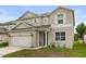 Charming two-story home with a two-car garage, and manicured front lawn at 1704 Pine Ridge Dr, Davenport, FL 33896