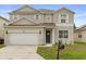 Charming two-story home showcasing a well-maintained lawn, attached garage, and a welcoming entrance at 1704 Pine Ridge Dr, Davenport, FL 33896