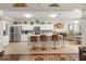 Expansive kitchen with white cabinetry, stainless steel appliances, tile flooring, chandeliers and a view into the living area at 1704 Pine Ridge Dr, Davenport, FL 33896