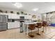 Bright kitchen with white cabinetry, stainless steel appliances, chandelier, tile flooring and a large island with seating at 1704 Pine Ridge Dr, Davenport, FL 33896