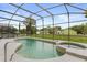 Private screened-in pool and hot tub area surrounded by lush greenery and ample space at 1704 Pine Ridge Dr, Davenport, FL 33896