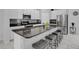 Modern kitchen with a granite countertop island, stainless steel appliances, and stylish bar stool seating at 178 Aberdeen St, Davenport, FL 33896