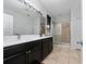 Bright bathroom featuring double sinks, walk-in shower, and large mirror at 205 Lakeshore Dr, Davenport, FL 33837
