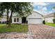Charming single-story home features a brick driveway and lush green lawn at 205 Lakeshore Dr, Davenport, FL 33837