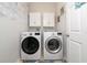 A well-organized laundry room featuring a modern washer and dryer set, with overhead cabinets at 205 Lakeshore Dr, Davenport, FL 33837